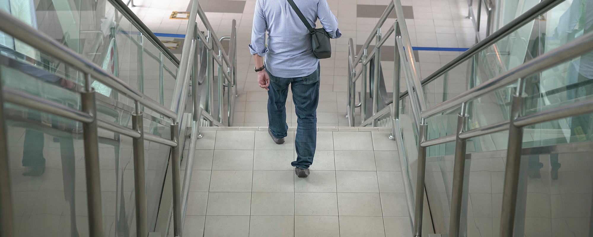man walking down the stairs inside a subway building.